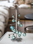 Decorative tree with turquoise glass ornaments on a white surface