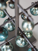 Close-up of a decorative chandelier with turquoise glass balls and metal frame.